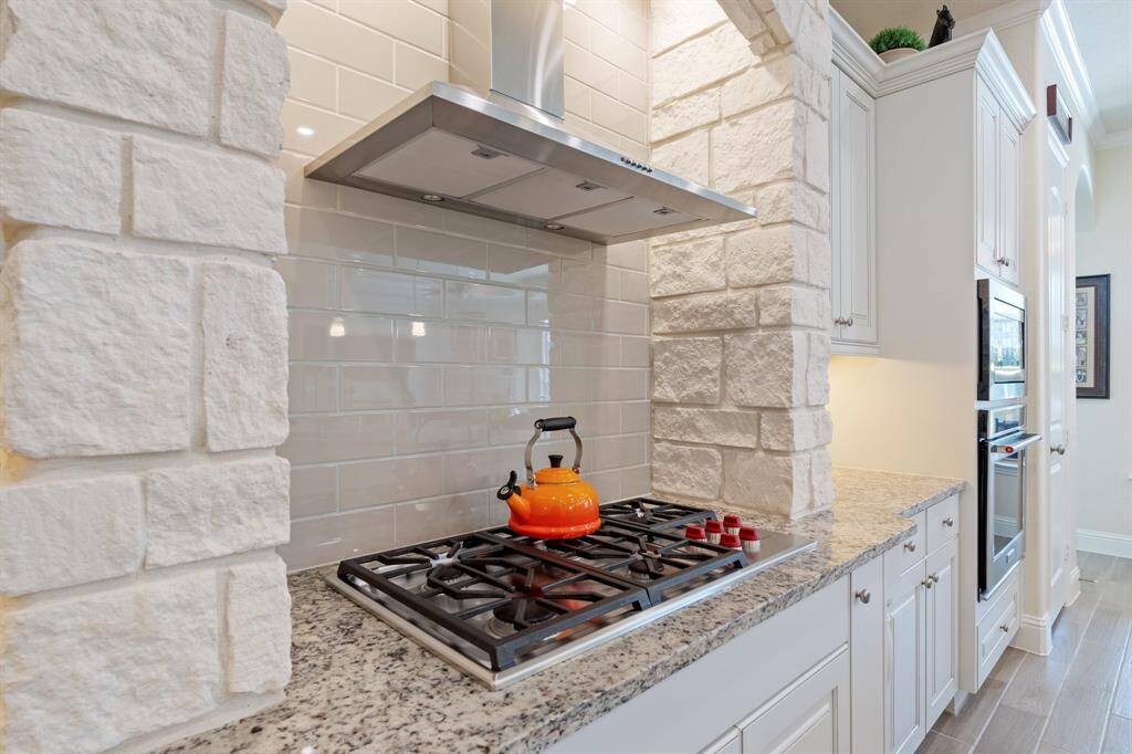 Gas WOLF cooktop is surrounded by beautiful white stonework adding a nice architectural touch to the space.