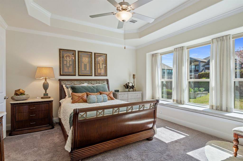The spacious Primary bedroom in the back of the home has pretty views of the lush landscaping in the backyard.