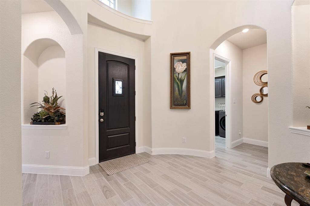 Upon entering the home, you walk into a gorgeous foyer with high ceiling and artwork niches in the walls. To the right down the hallway are the two secondary bedrooms and the office.