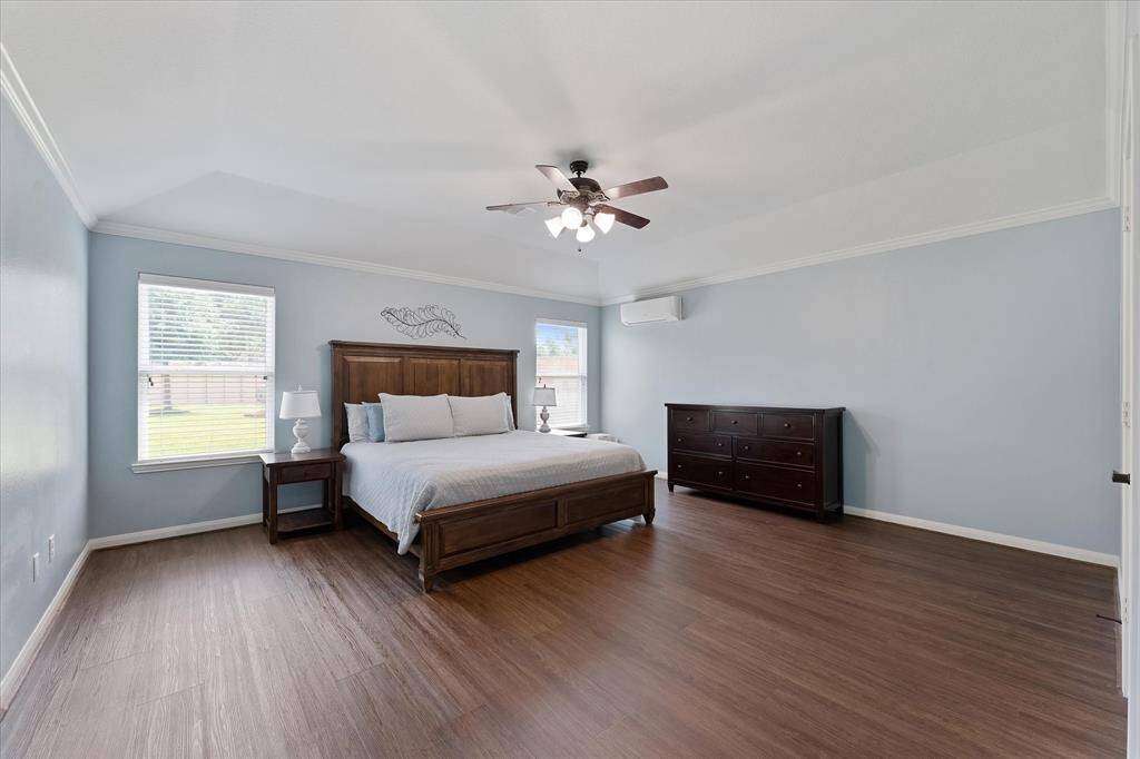 Private primary suite with luxury vinyl flooring, high ceiling and views to the backyard