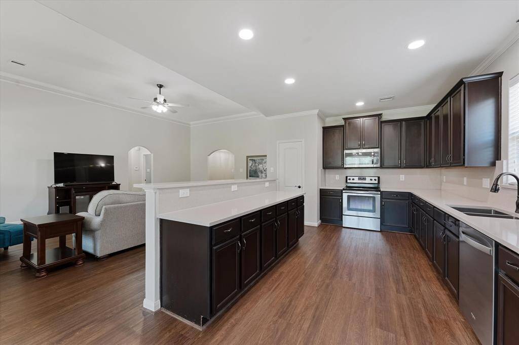 Gourmet kitchen with high/low cabinetry, stainless appliances and recessed lighting