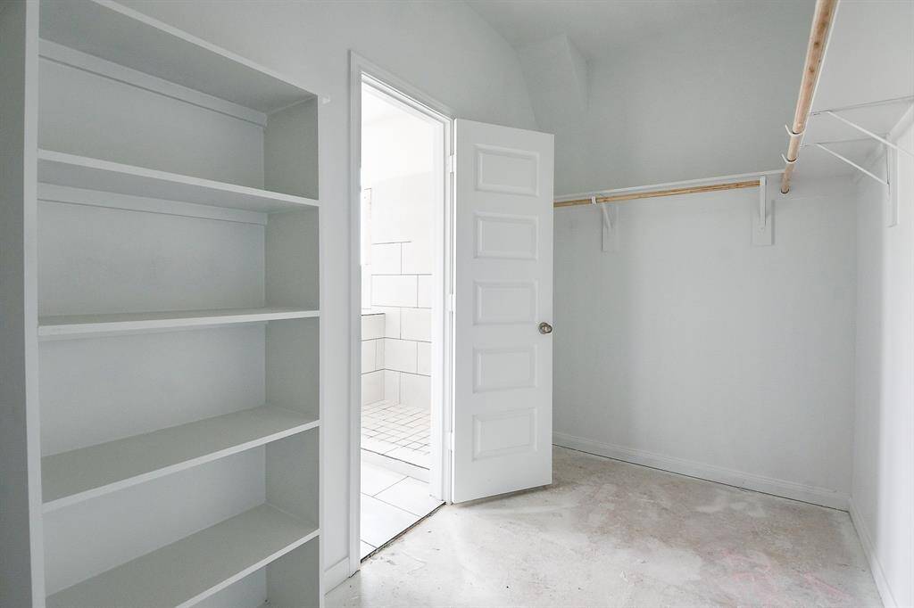 Step into this spacious walk-in closet with built-in storage shelves.