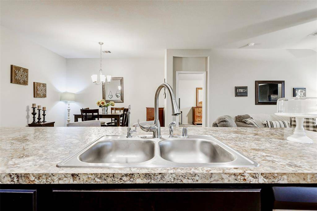 The expansive countertops provide ample prep space, while a thoughtfully designed double-basin sink is equipped with a modern gooseneck faucet and a reverse osmosis water spout for added convenience.