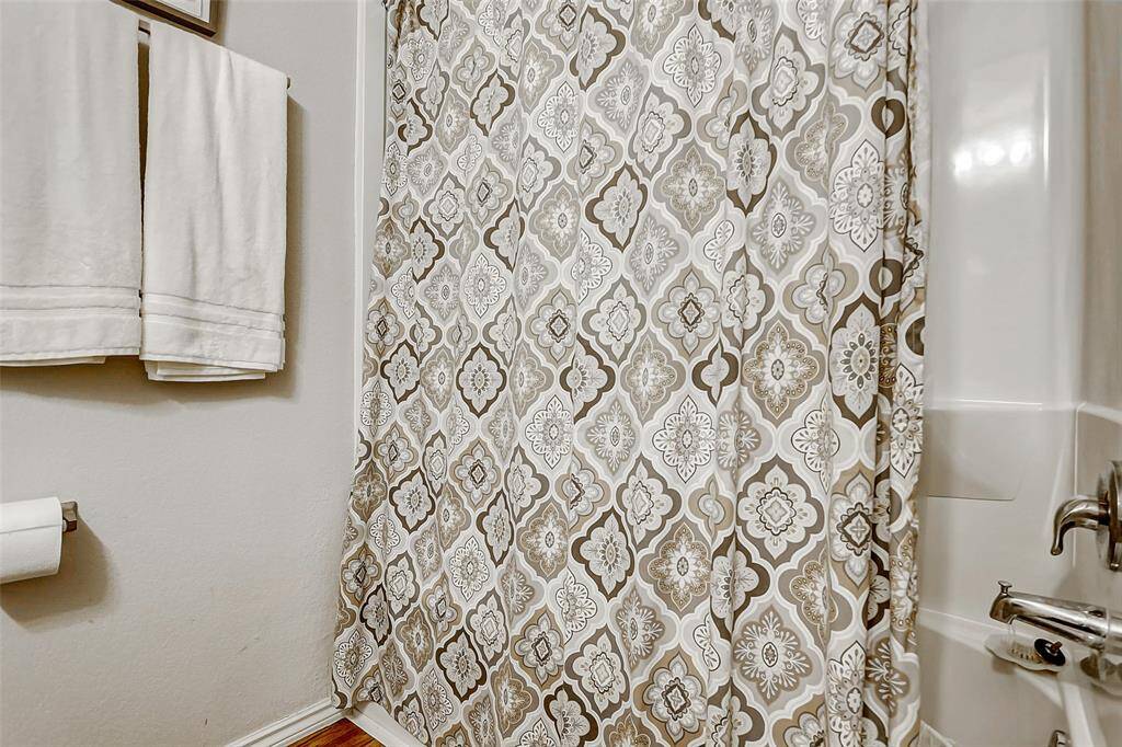 The secondary bathroom features an oversized tub/shower combo, offering versatile bathing options whether you’re looking for a quick rinse or a relaxing soak.