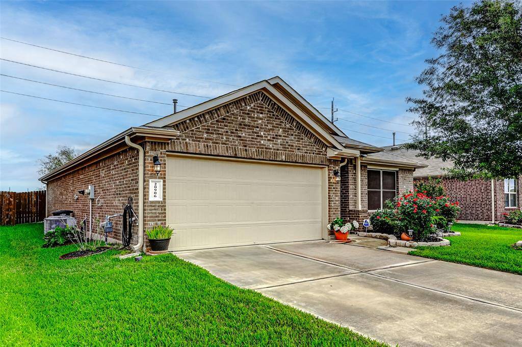 The doublewide driveway provides plenty of parking space and leads directly to a two-car attached garage, offering convenience and additional storage options.