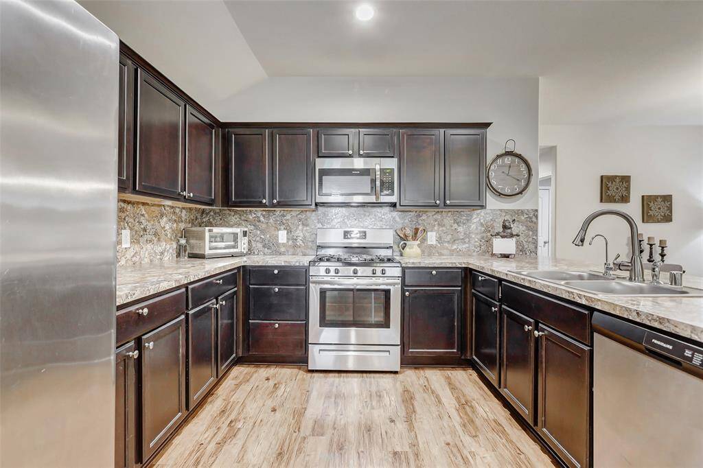 Sleek stainless steel appliances, including a gas range and built-in microwave, deliver both performance and versatility, whether you're preparing quick weeknight meals or hosting a weekend gathering.