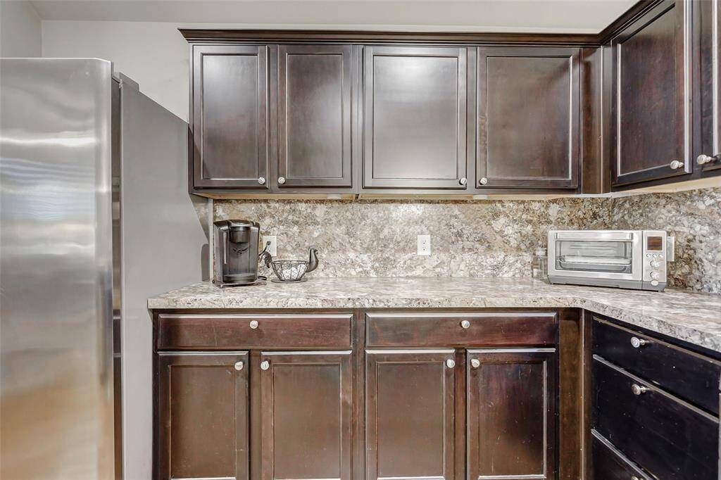 Rich, dark-stained cabinetry offers a timeless look while providing generous storage for all your kitchen essentials.