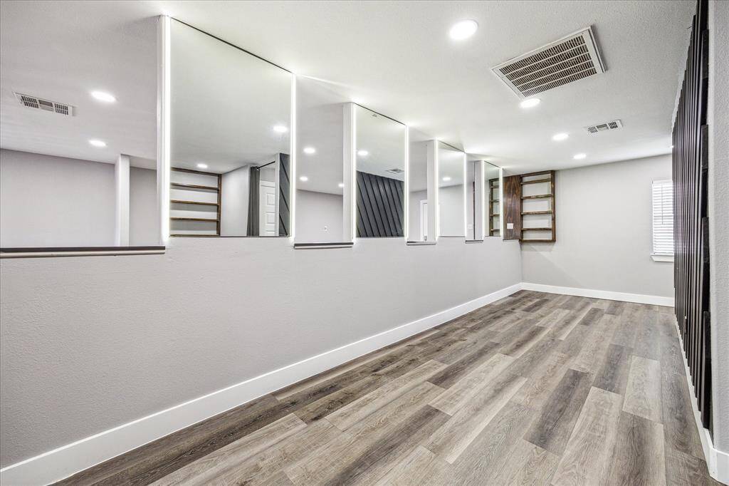 Stylish space featuring wall shelves, soft lighting, mirrored accents, and refined baseboards.