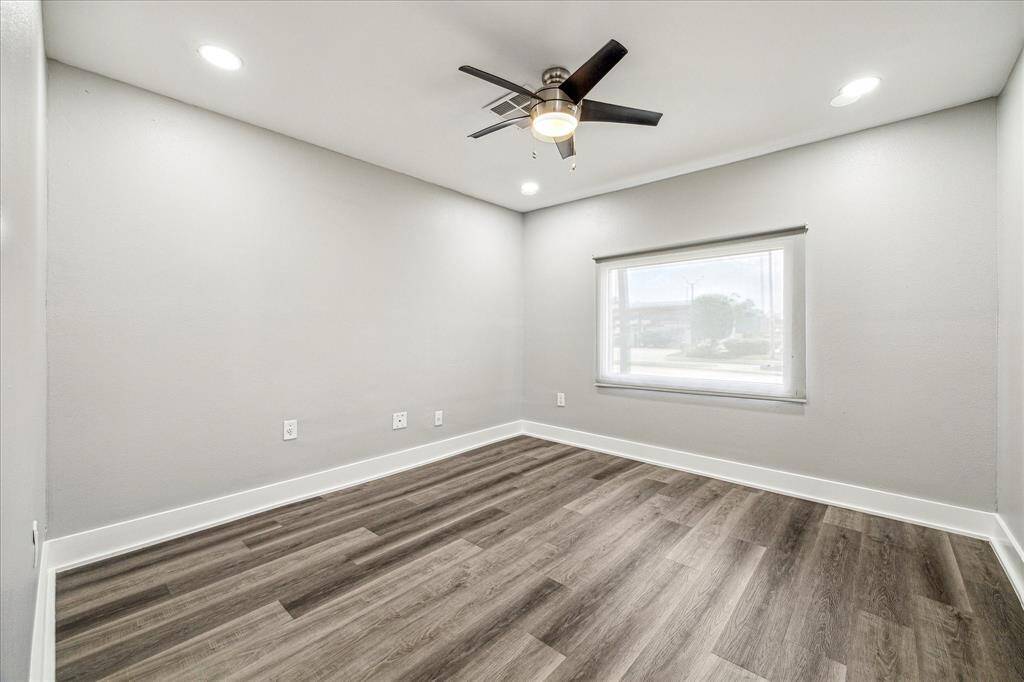 Light-filled room with ceiling fan and sleek recessed lighting.