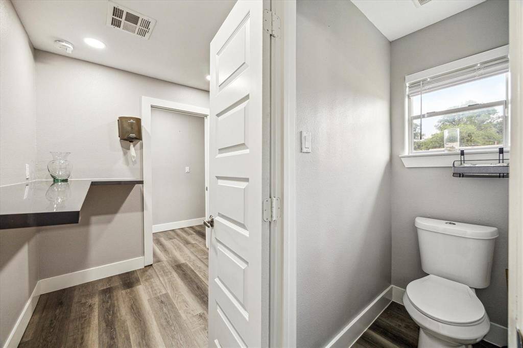 Bright, well-lit bathroom featuring a toilet and modern recessed lighting.