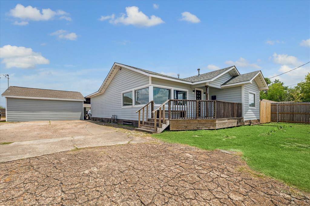 Front exterior featuring the garage and spacious lawn.