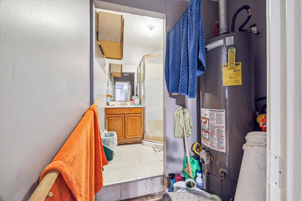 Well-lit area with a sink, mirror, and functional base cabinet.