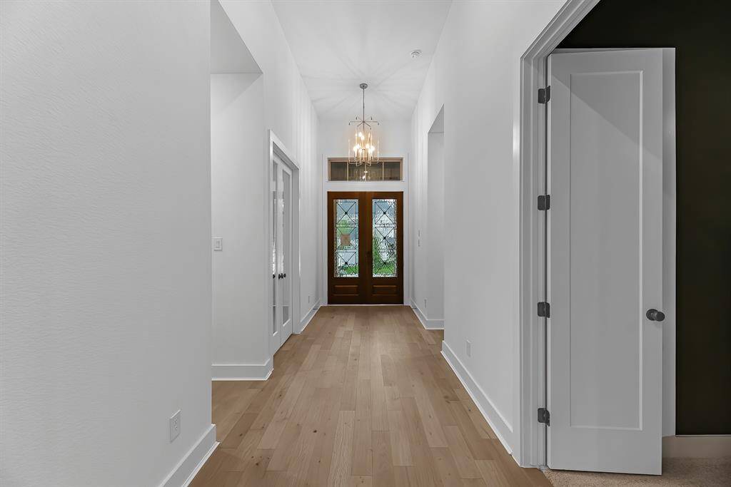 This stunning view features the double door entry, private home office to the left, and entry doors to the entertainment/media room!