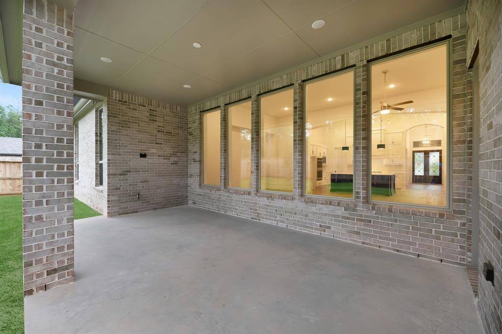 View of the covered back patio showing inside into the family room and kitchen.