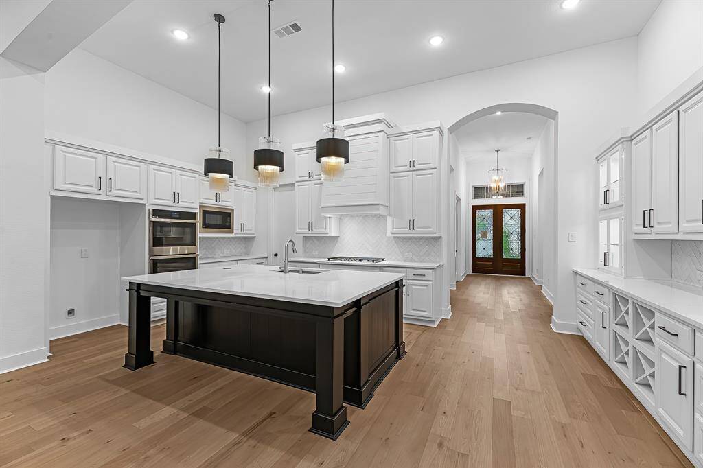 Dramatic entry! View of the double doors, hall, and kitchen from the family room.