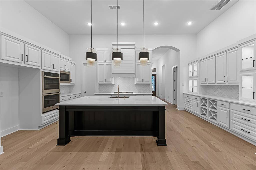 Ample prep and storage space. Kitchen includes a walk-in pantry, quartz counters, and oversized island.