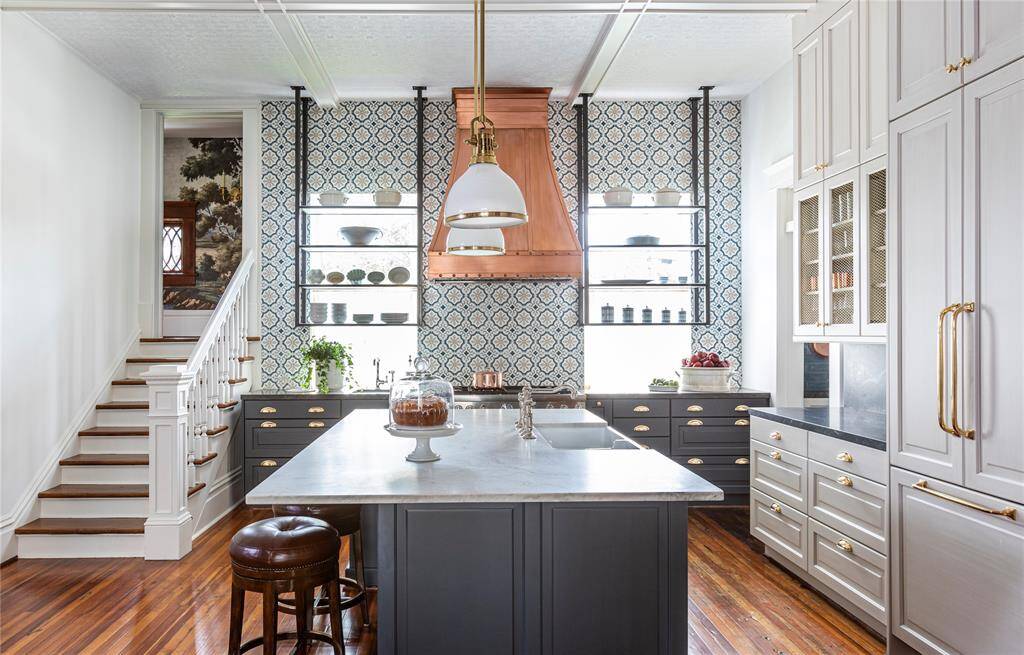 A thoughtful blend of metals enhances the warmth of the space. Brass and nickel finishes play together beautifully, while a paneled refrigerator blends seamlessly into the cabinetry for a clean, timeless look.