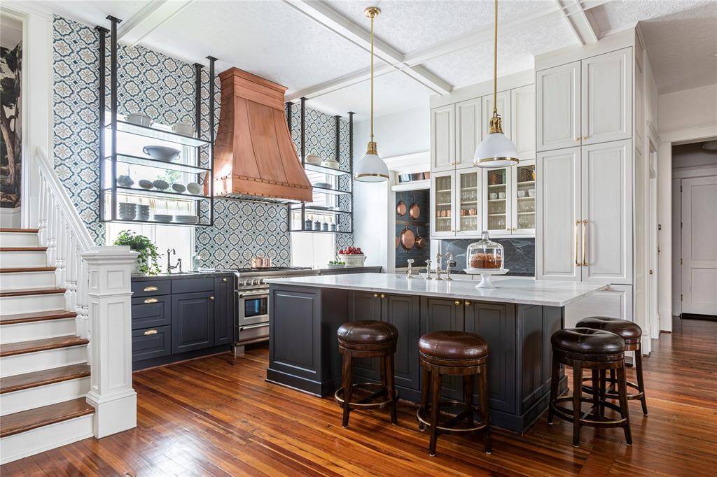 Every inch of the kitchen has been carefully curated. With custom open shelving, hand-crafted cabinetry by Wood-Mode and McCaw Custom Cabinetry, built-in wine storage, and Thermador appliances — including a paneled refrigerator — the space offers designer appeal and culinary performance.