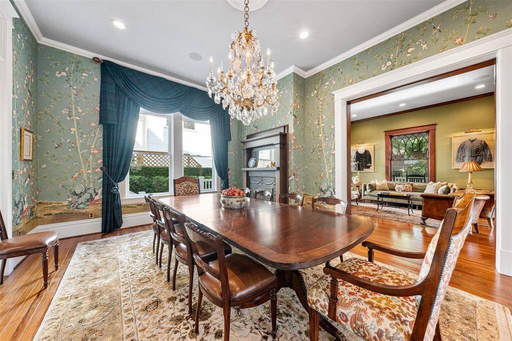 The formal dining room stands as a testament to the home's legacy of entertaining. Part of the original 1903 layout, it remains perfectly suited for hosting grand dinners and intimate celebrations—now elevated by Schumacher wallpaper, custom draperies, and an elegant chandelier that together create a refined and inviting atmosphere.