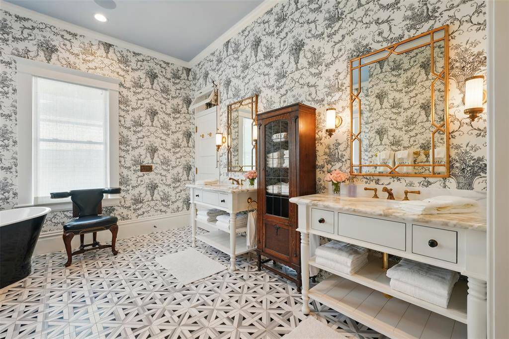 A show-stopping blend of elegance and artistry, this space stuns with Thibaut wallpaper, Ann Sacks marble tile, and dual vanities topped with Calacatta Gold marble. Brass fixtures and gold-accented mirrors complete the luxurious, thoughtfully layered design.