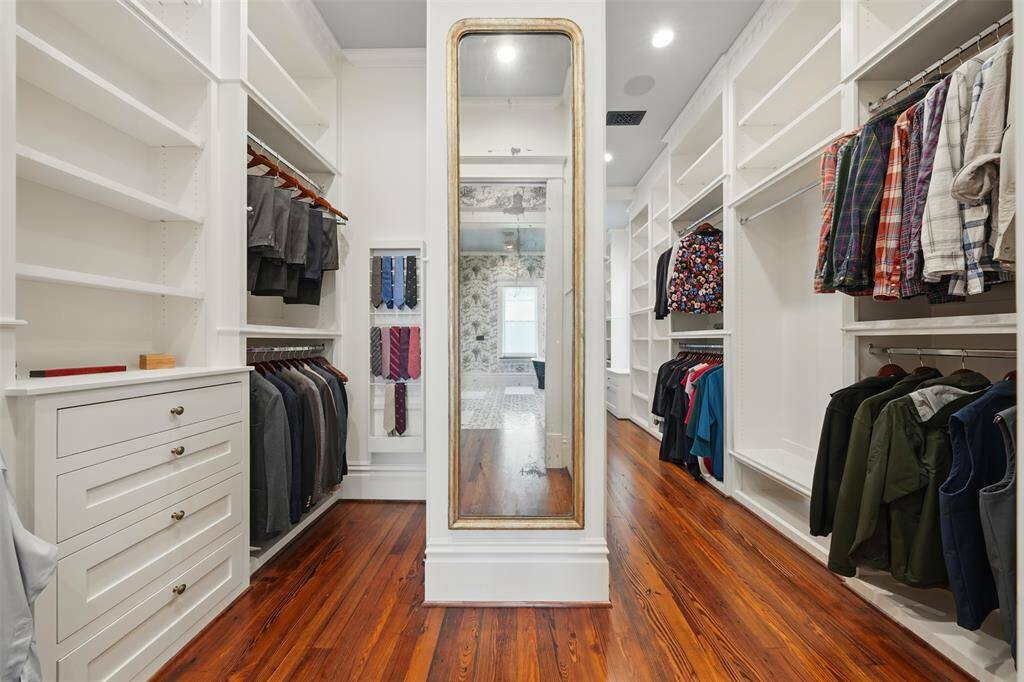 Custom built-ins, hanging space, drawers, and a full-length mirror are thoughtfully arranged to maximize both function and style. With hardwood floors and generous scale, this primary closet is as refined as the rest of the home.