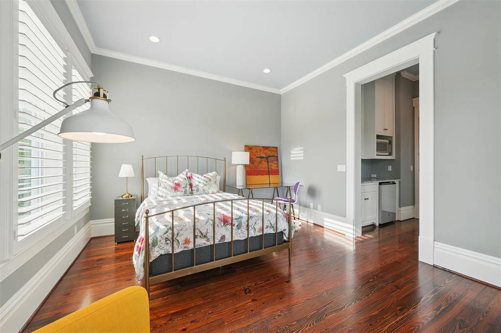 A serene and self-contained guest retreat. This light-filled bedroom features timeless trim work, rich hardwood floors, an en-suite bath and a built-in kitchenette—ideal for use as a guest suite, in-law quarters, or a private studio-style space within the home.