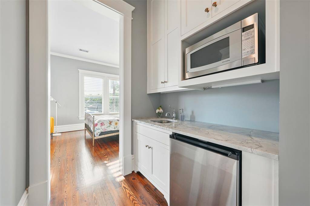 Chic and convenient, this private kitchenette makes independent living seamless. Featuring sleek cabinetry, dolomite countertops, a built-in microwave, undercounter fridge, and prep sink, it’s an ideal amenity for long-term guests, in-laws, or as a studio suite refreshment station.