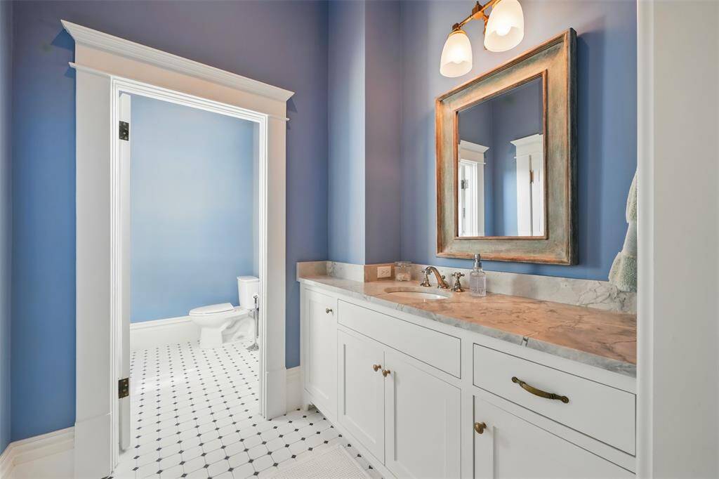 Classic charm meets modern comfort. With soft periwinkle walls, dolomite countertops, vintage-inspired fixtures, and timeless tile flooring, this bathroom offers a fresh, refined aesthetic that perfectly complements the home’s overall historic elegance.