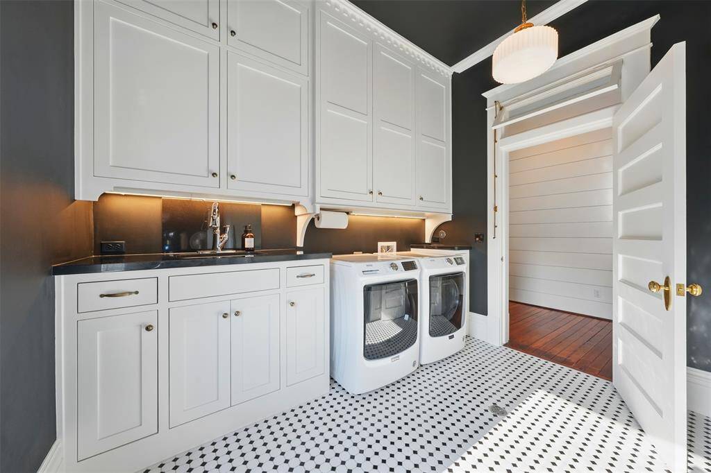 The laundry room includes a sink, cabinetry to the ceiling, more storage on the opposite side and an additional nook for steaming and ironing.  Like all of the upstairs rooms, the six-panel doors are capped with a working transom.