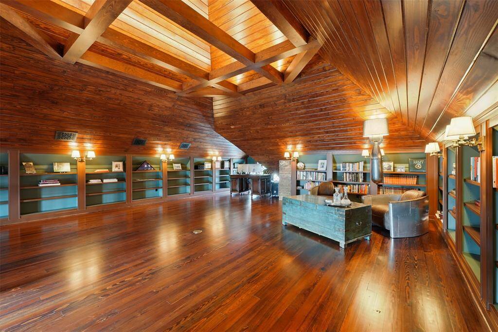 A dramatic third-floor retreat rich in architectural detail. With vaulted wood ceilings, exposed beams, and warm pine floors, this expansive flex space offers character and craftsmanship rarely seen in modern construction.