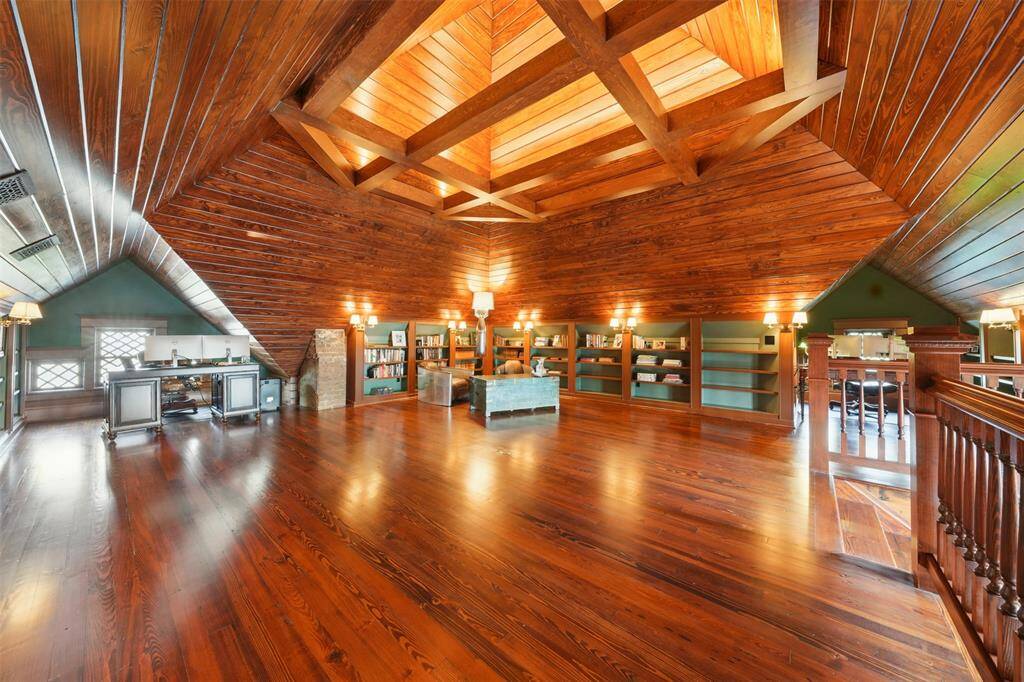 A versatile space with limitless potential. Custom built-in bookshelves, cozy seating nooks, and open floor space make this the perfect setting for a home office, library, studio, game room, exercise studio or lounge.