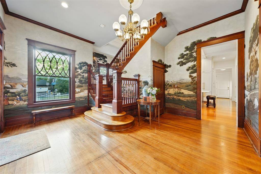 The sense of entry is rich in history and character. The original pine floors have been lovingly restored, their natural patina left intentionally untouched. Custom millwork was seamlessly integrated to match original molding. Period-style fixtures pair beautifully with modern recessed lighting, and the dual-sided staircase retains its original detailing and stair treads.