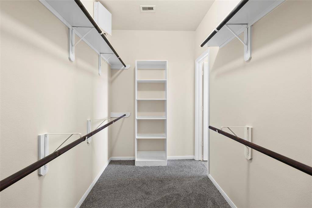 Your primary suite is complete with a spacious walk-in closet, offering built-in shelving and ample hanging space to keep everything organized and easily within reach.