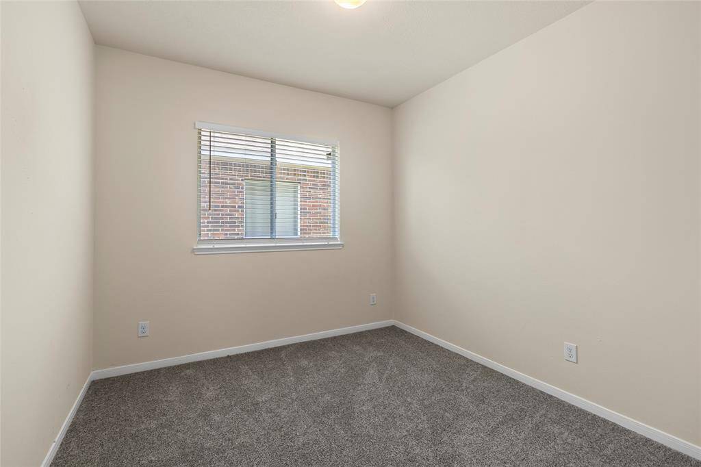 This cozy room offers a quiet space with soft carpeting and a window that brings in natural light—perfect for a bedroom, home office, or hobby room to make your own.
