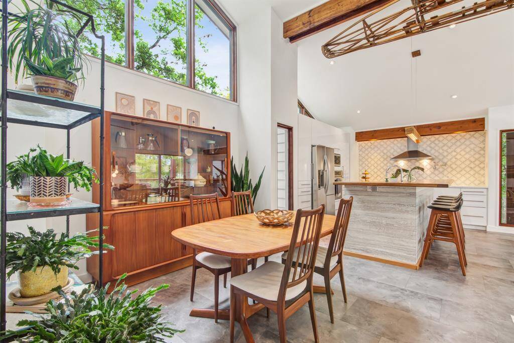 Open plan dining/kitchen/living space has large tile flooring throughout. Vaulted ceiling with recessed LED lighting.
