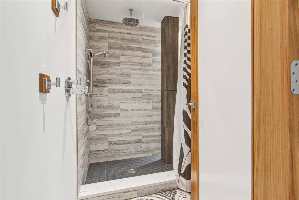Guest bathroom with teak door, gorgeous tile, rain head and wall mounted shower, additional controls on outside for convenience.