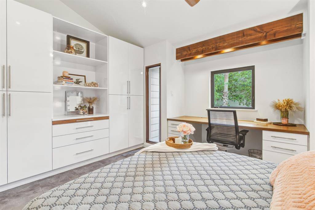 Guest bedroom maximizing space with custom built in cabinetry and teak desk.
