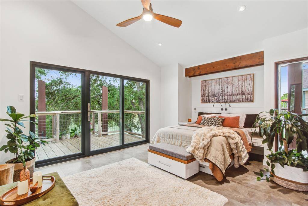 Primary bedroom has vaulted ceiling and private deck with hurricane sliding door.