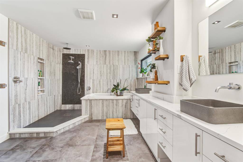 Primary bathroom is spacious with large open shower, deep soaker tub with self cleaning jets, double sink custom vanity.