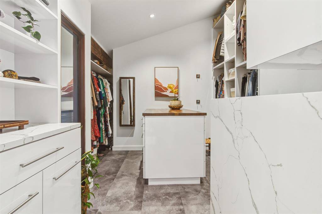 Dream closet! Fully customized cabinetry and so much well thought out storage space. Center island has reclaimed English oak counter top. Beautiful and elegant. Vaulted ceiling adds to the spaciousness.