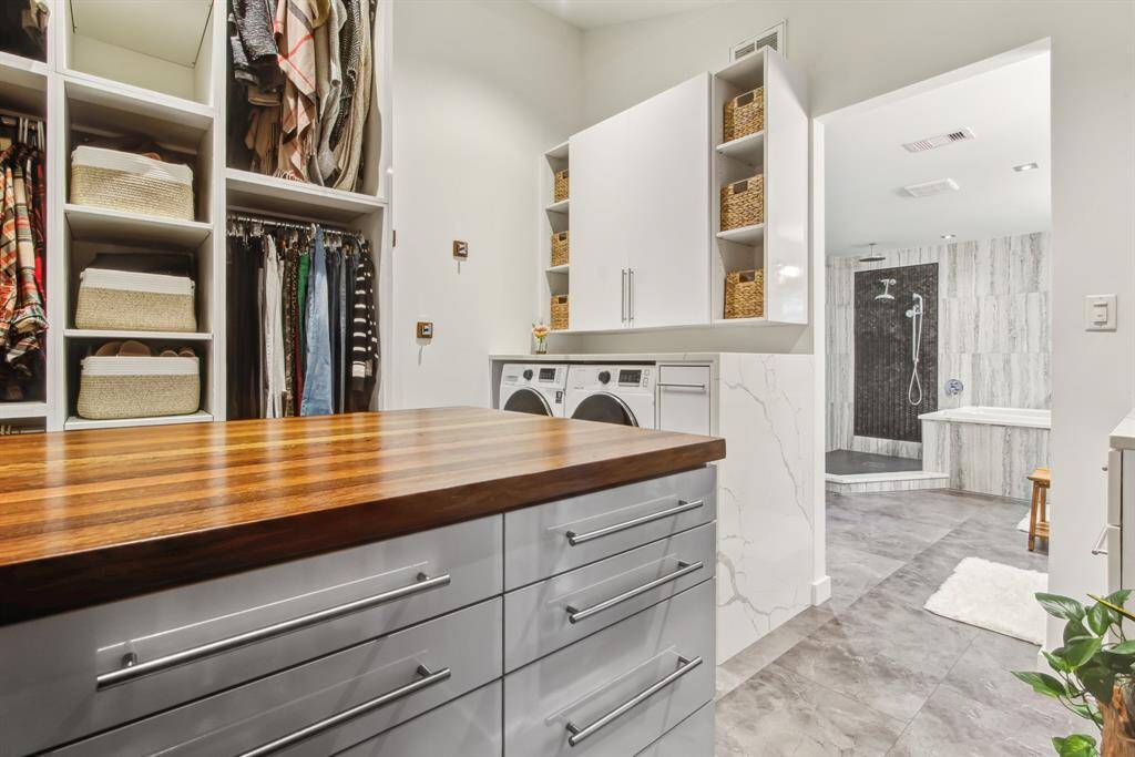 View of English oak counter top on storage island in walk in closet. notice the water fall quart surround to washer and dryer.