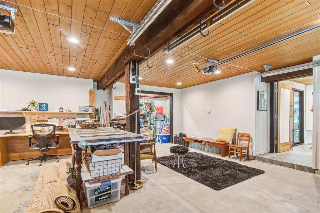Two car garage has remote openers, tongue and groove finished ceiling with recessed lights, additional storage space, built in work bench and AC unit. Flexible space can also be used to park cars!