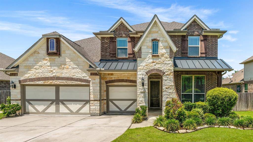 stately stone facade, lush landscaping adds to the beautiful elevation