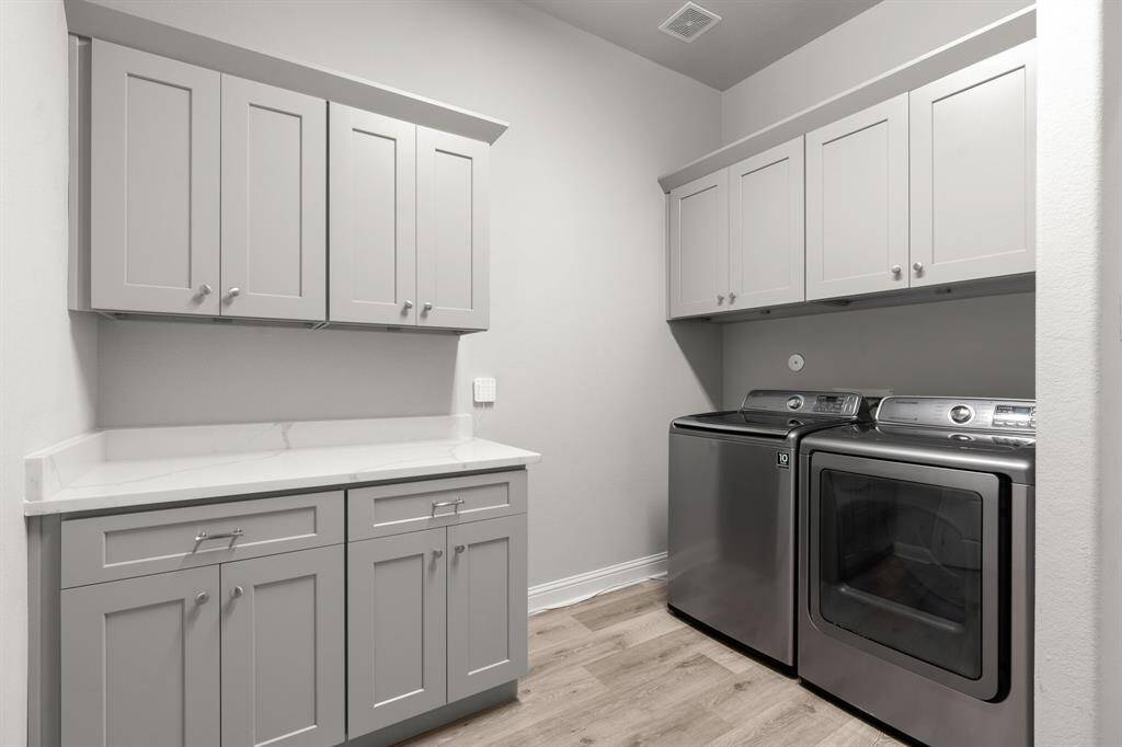spacious laundry room with ample cabinetry