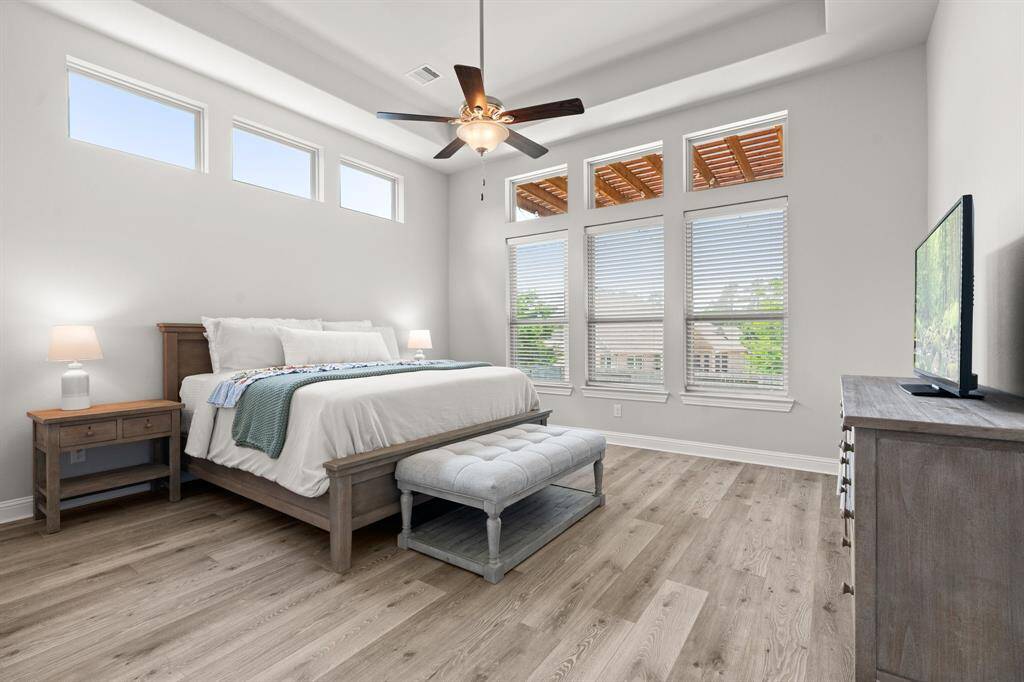beautiful primary with shelf ceiling and natural light
