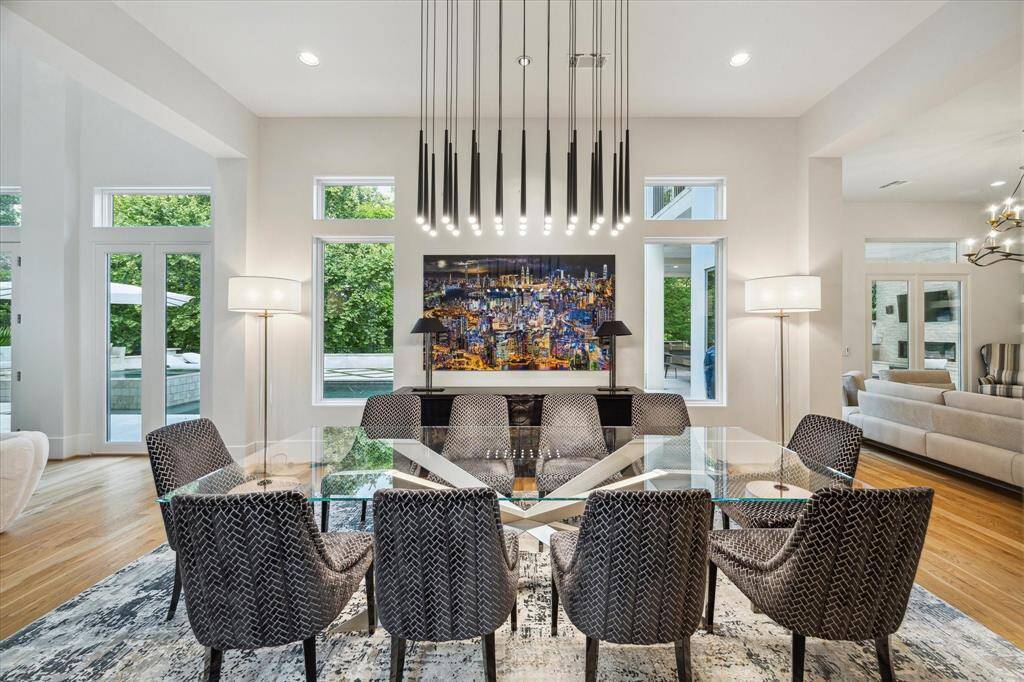 This luxurious dining room features expansive windows that flood the space with natural light, highlighting the high ceilings.