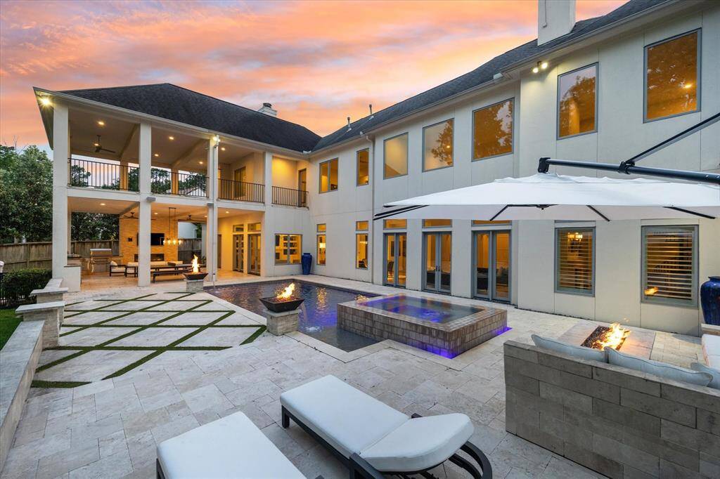 This home showcase unparalleled luxury, with this breathtaking outdoor space. he covered outdoor kitchen and dining area are perfect for entertaining, while the two-story home boasts large windows and an upper balcony offering stunning views.