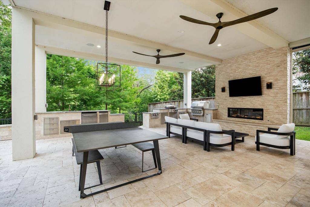 Indulge in outdoor luxury at with this exquisite covered patio. Featuring a cozy fireplace and a state-of-the-art stainless steel grill with ample counter space, this space is perfect for entertaining.