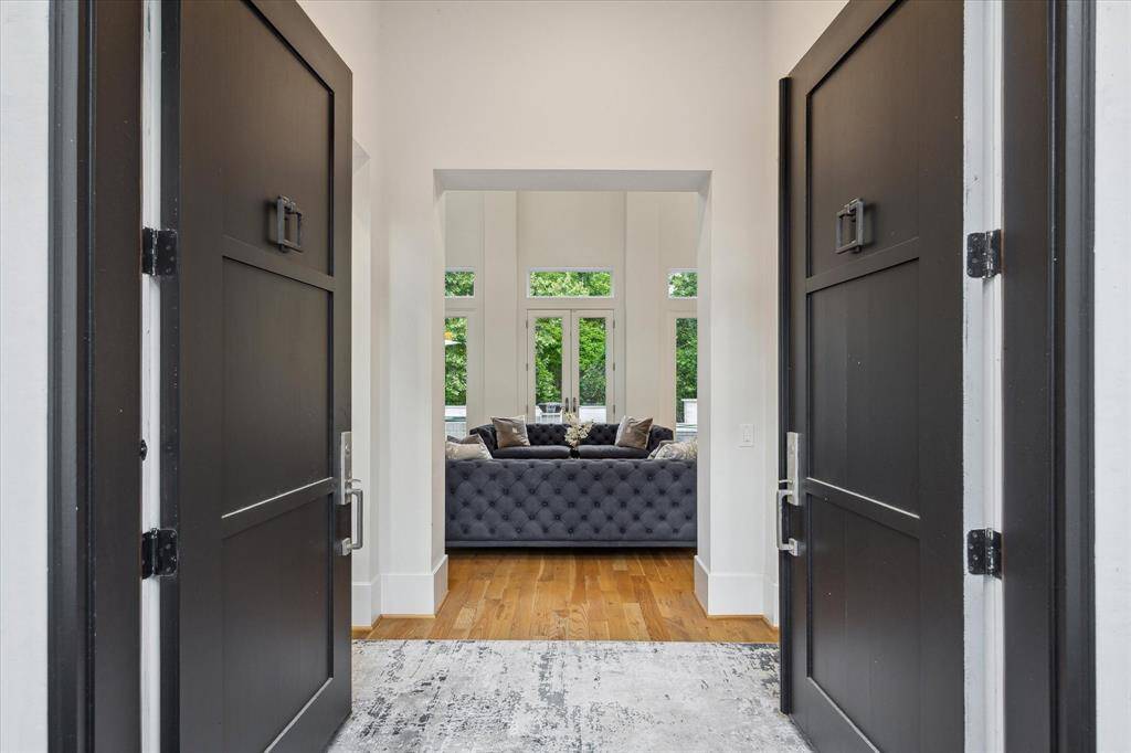 Step into elegance at 22 East Shade Lane, Houston, through grand double doors, revealing a sophisticated living area.