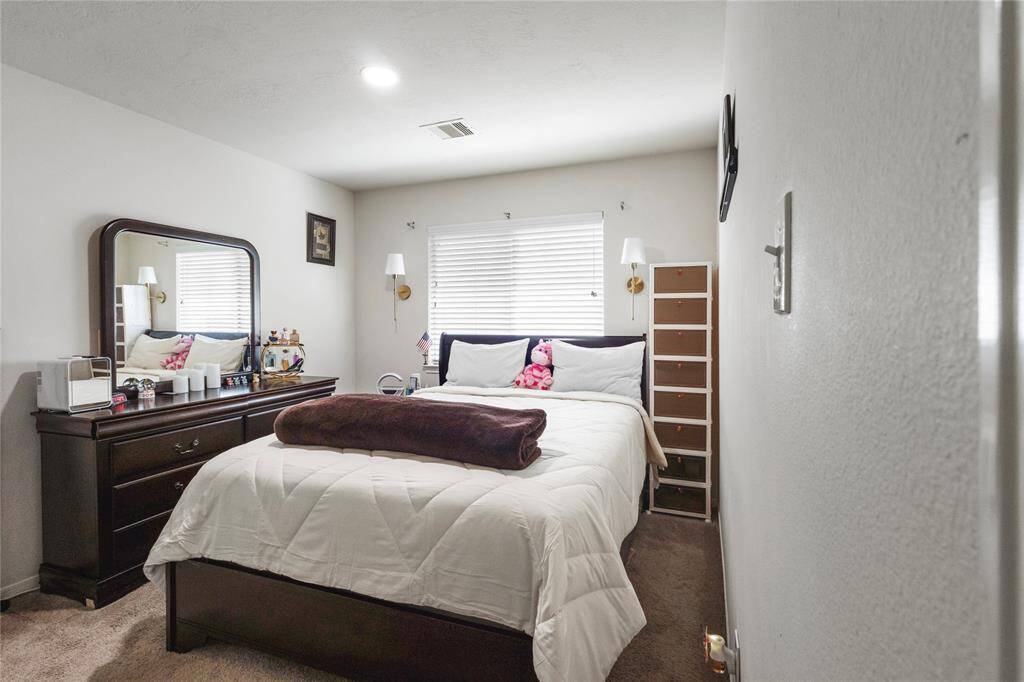 Cozy and inviting, this bedroom features ample natural light and plush carpeting..